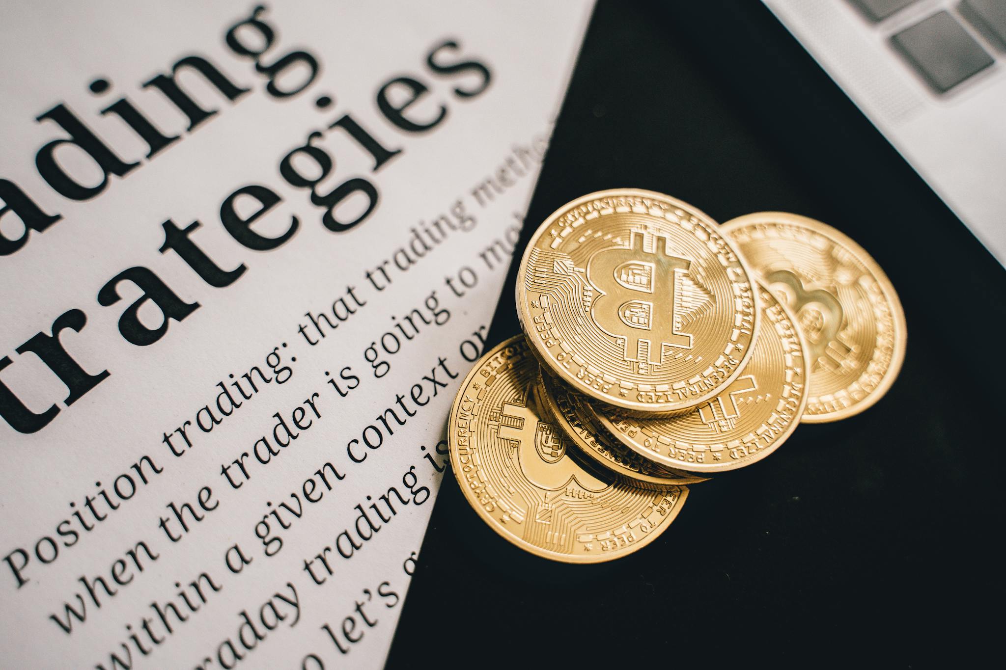 Close-up of gold Bitcoin coins on a trading document, symbolizing investment and cryptocurrency market strategies.